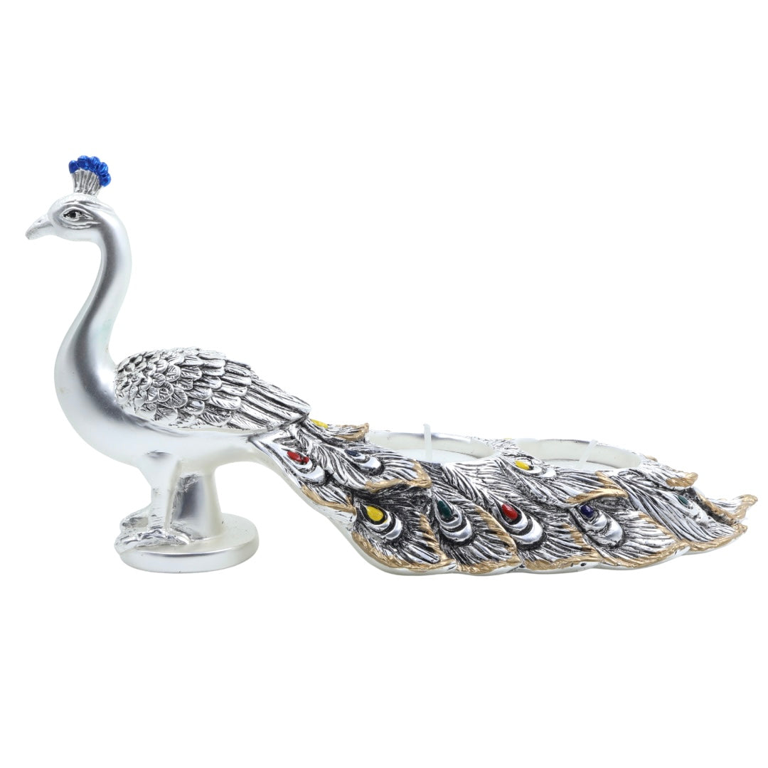 Decorative silver peacock-shaped tealight holder with colorful feather detailing — ideal for festive décor or gifting.